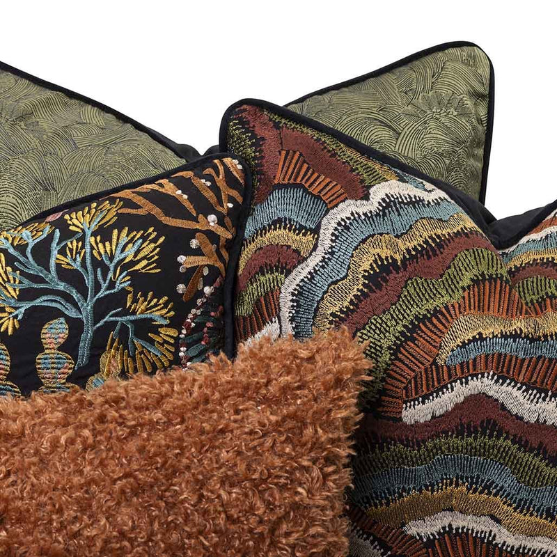 Moana Set by Giava Interiors – decorative scatter cushions with burnt orange boucle, embroidered botanical patterns, and green textured fabrics arranged in a stylish layered display.