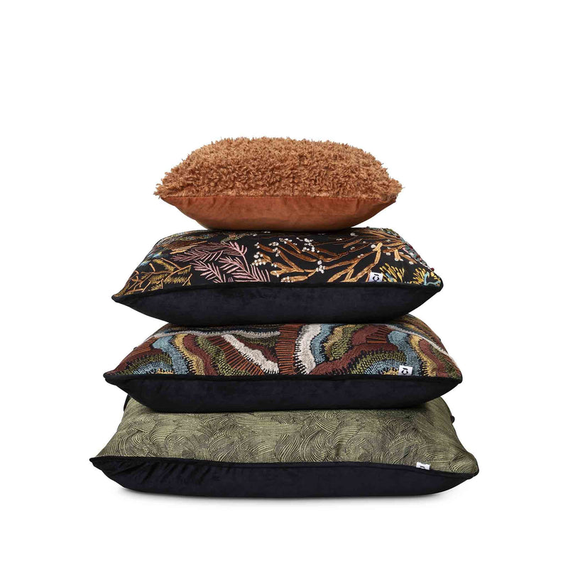 Moana Set by Giava Interiors – decorative scatter cushions with burnt orange boucle, embroidered botanical patterns, and green textured fabrics arranged in a stylish layered display.