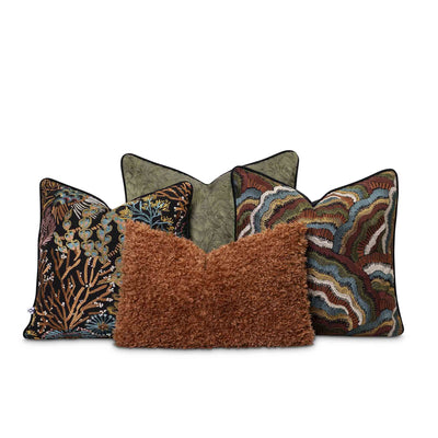 Moana Set by Giava Interiors – decorative scatter cushions with burnt orange boucle, embroidered botanical patterns, and green textured fabrics arranged in a stylish layered display.